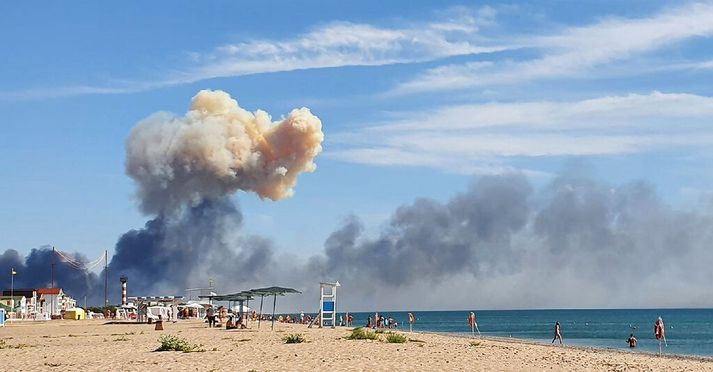 Mikill reykur blasti við strandgestum í Saky eftir röð sprenginga á herstöð Rússa á svæðinu.