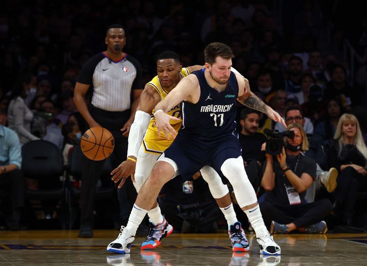 Russell Westbrook reynir að stela boltanum af Luka Doncic.