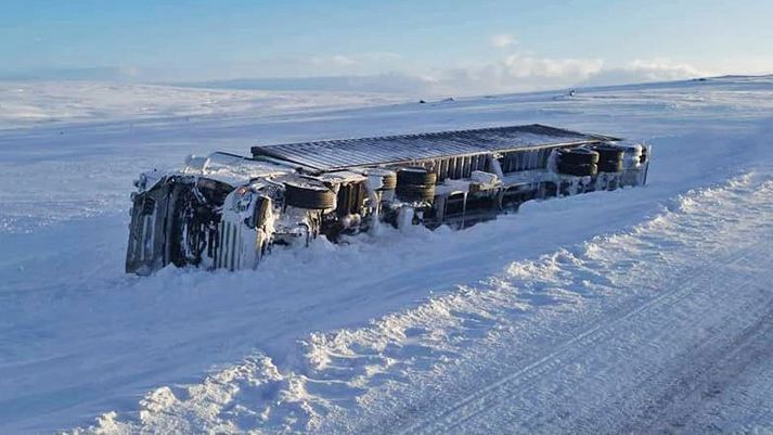 Unnið er að því að ná upp flutningabifreið sem valt þar í morgun.