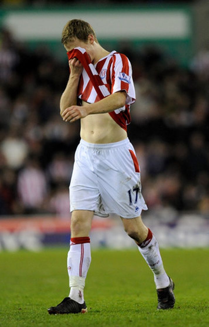 Ryan Shawcross gengur niðurlútur af velli eftir að hafa fótbrotið Aaron Ramsey.