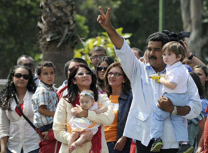 Maduro Forsetaefni sósíalista veifar til fjöldans þegar hann mætir á kjörstað ásamt fjölskyldu sinni í Karkas, höfuðborg Venesúela í gær.nordicphotos/afp