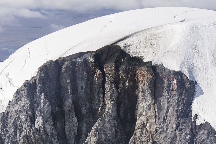 Svört rönd gengur skáhallt upp jökulinn frá því sem virðist vera forn gjallgígur á tindi Hvannadalshnjúks. Myndin var tekin 25. ágúst 2023.