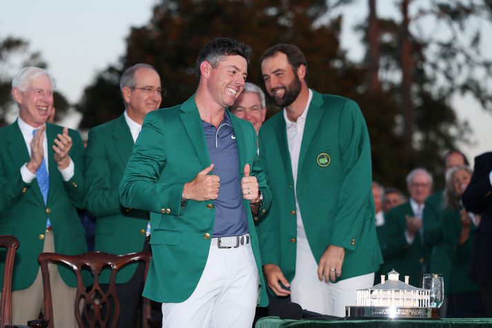 Rory McIlroy brosti út að eyrum þegar hann var kominn í græna jakkann í gær.