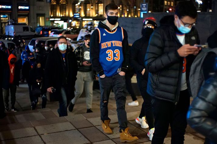 Áhorfendur sjást hér tínast inn í Madison Square Garden í New York á þriðjudag til að fylgjast með leik New York Knicks og Golden State Warriors. Var þetta í fyrsta skipti sem áhorfndur voru leyfðir í höllinni síðan faraldurinn skall á.