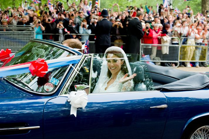 Brúðhjónunum brá fyrir í Aston Martin blæjubíl eftir brúðkaupið í dag. Mynd/ afp.