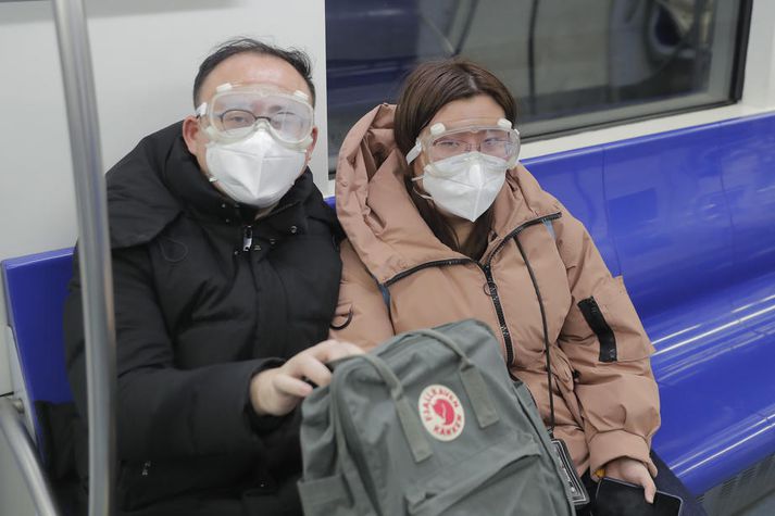 Þetta fólk er bæði með grímur og hlífðargleraugu þar sem það ferðast um í neðanjarðarlestarkerfi í nágrenni Beijing.