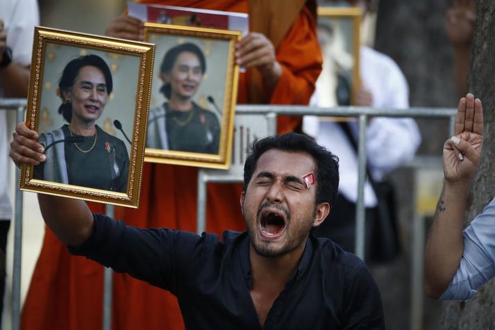 Mótmælandi heldur á mynd af Aung San Suu Kyi sem herinn steypti af stóli í byrjun febrúar. Herinn sakar Suu Kyi um stórfellda mútuþægni.