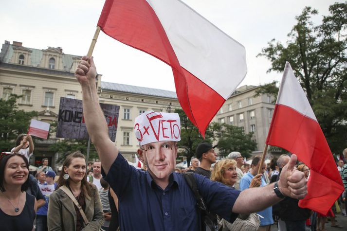Maður með grímu sem líkist Duda forseta mótmælir umdeildum lögum ríkisstjórnarinnar um dómstóla.