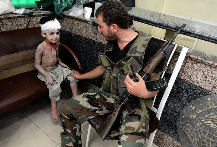 Á sjúkrahúsi í Aleppo Særður drengur ásamt uppreisnarmanni.nordicphotos/AFP