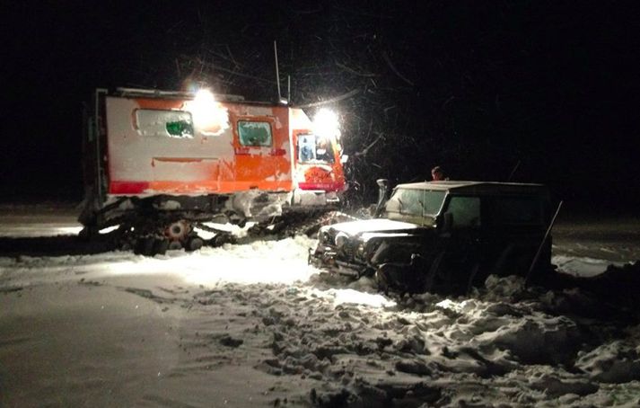 Mynd frá vettvangi í nótt þar sem sjá má bifreið íslensku ferðalanganna og snjóbíl björgunarsveitarmanna.