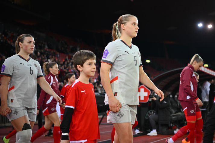 Emilía Kiær Ásgeirsdóttir (til hægri) fær tækifæri í byrjunarliðinu gegn Noregi. Ingibjörg Sigurðardóttir (til vinstri) leiðir íslenska liðið út á AVIS-völlinn í Laugardalnum á eftir.