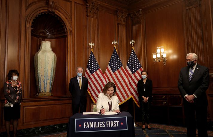 Forseti Bandaríkjaþings, Nancy Pelosi undirritar aðgerðapakkann.