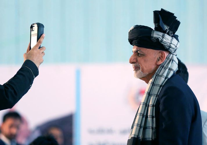 Ghani forseti stillir sér upp fyrir mynd á kjördag í september.