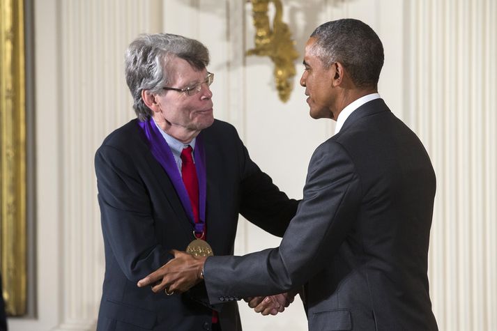 Stephen King (t.v.) þiggur orðu úr hendi Baracks Obama. King er síður hrifinn af eftirmanni Obama í embætti forseta.