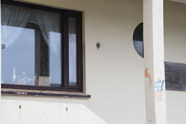 Skotið hafnaði í vegg við hlið eldhúsglugga, og mesta mildi þykir að ekki varð slys af þar sem maður stóð í glugganum.