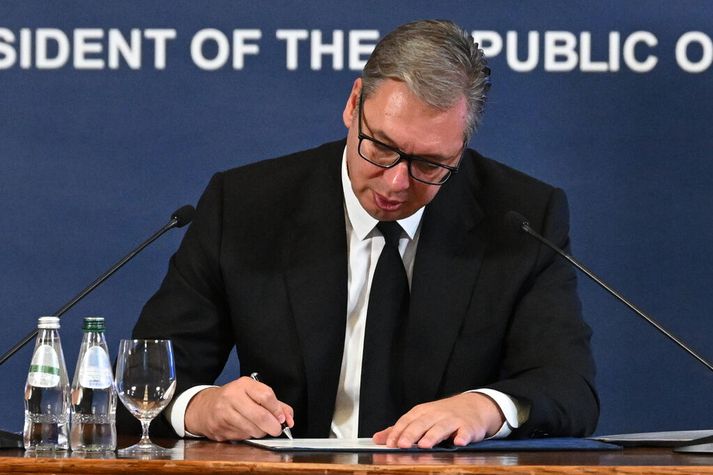 Á myndinni má sjá Aleksandar Vucic, forseta Serbíu, undirrita afsögn sína sem forseti lýðveldisins.