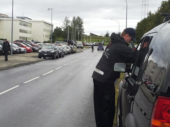 Bílastæðaverðir sekta fyrir utan Laugardalshöll.