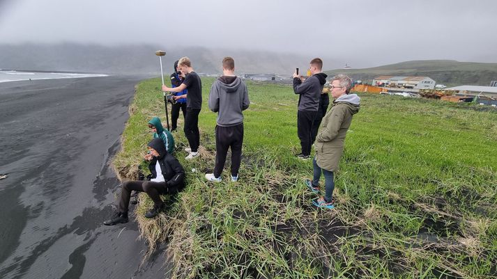 Nemendur Víkurskóla að vinna að strandlínurannsóknum í Víkurfjöru með sín tól og tæki.