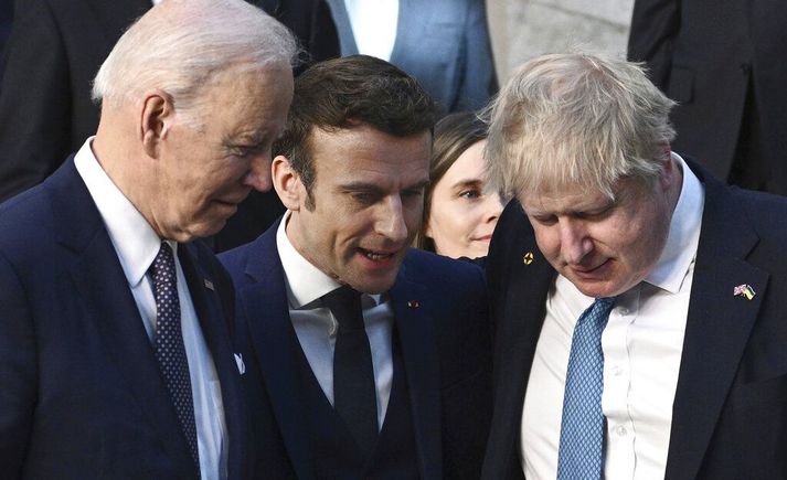 Joe Biden forseti Bandaríkjanna, Emmanuel Macron forseti Frakklands og Boris Johnson forsætisráðherra Bretlands stinga saman nefjum í upphafi leiðtogafundar NATO í morgun. Á milli Bidens og Macrons má sjá glitta í Katrínu Jakobsdóttur forsætisráðherra.