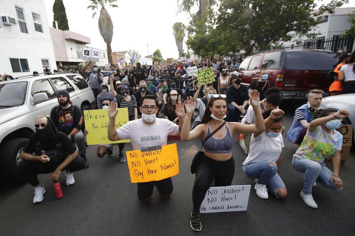 Mótmælendur krjúpa fyrir framan lögreglumenn í Los Angeles í gær.