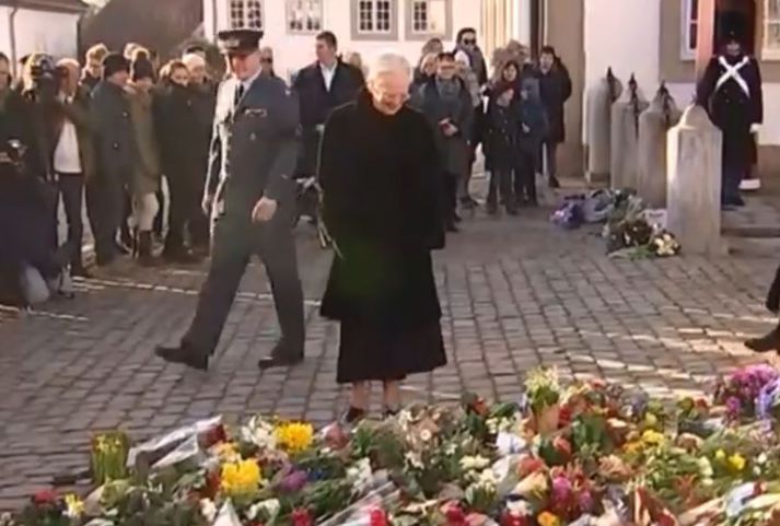 Drottningin var klædd síðri svartri kápu og heilsaði þar upp á þá sem höfðu lagt leið sína þangað.