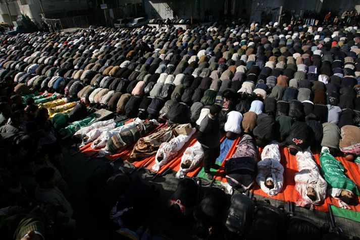 Palestínumenn biðja fyrir framan lík fjörtíu og tveggja manna sem létust í árás á skóla sameinuðu þjóðanna á Gaza.