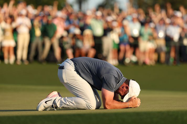 Rory McIlroy fagnar hér sigri á Mastersmótinu í gær eftir að sett niður pútt á átjándu.