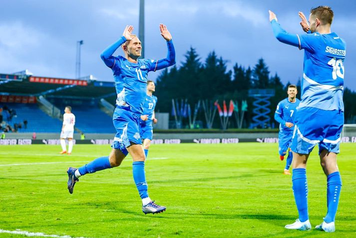 Jón Dagur fagnar með Gylfa Þór sem gaf stoðsendingu úr hornspyrnu.