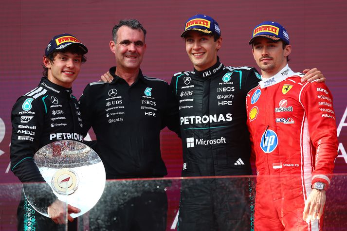 Mercedes menn brosandi á verðlaunapalli en Charles Leclerc hjá Ferrari með fýlusvip. 