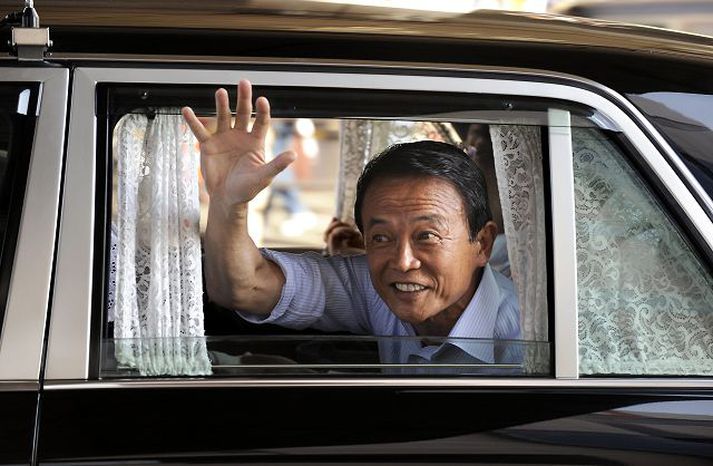 Taro Aso Forsætisráðherra Japans veifar til kjósenda úr bifreið sinni.
nordicphotos/AFP