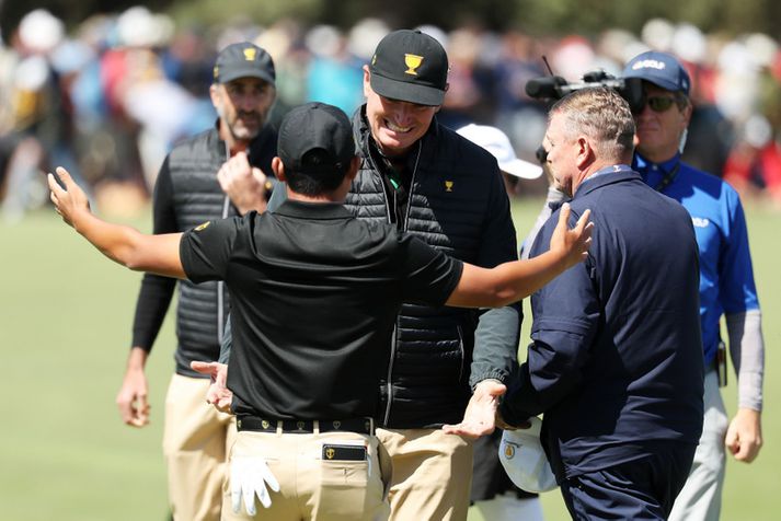 Ernie Els, fyrirliði heimsúrvalsins, fagnar með  C.T. Pan í nótt.