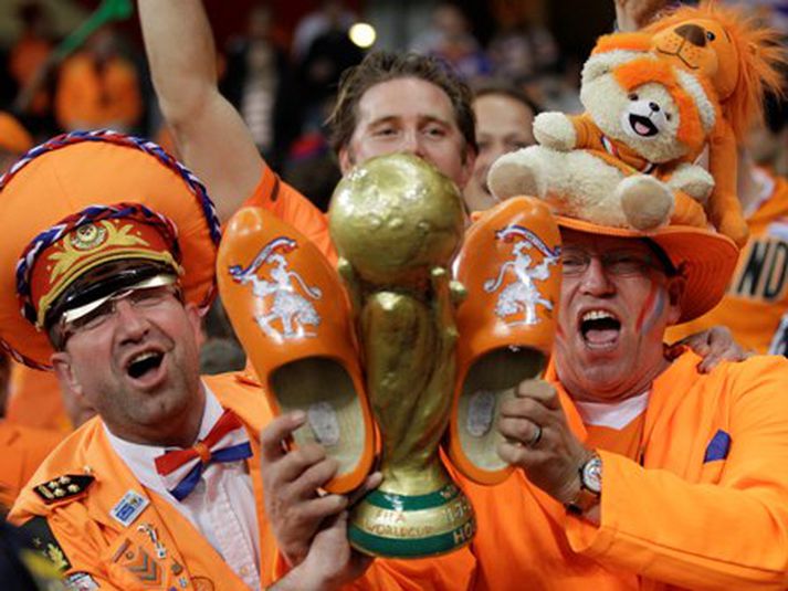 Ekki er óheimilt að gera eftirlíkingar af verðlaunastyttunni. Hér sjást kátir Hollendingar í Suður-Afríku með eina slíka. Lið Hollands á möguleika á að tryggja sér hina einu sönnu verðlaunastyttu á sunnudaginn eftir viku. Mynd/AP