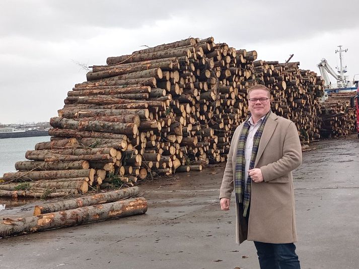 Valdimar Víðisson bæjarstjóri stillir sér sposkur á svip upp við timburstaflann. Hafnfirðingar já í þessu tækifæri.