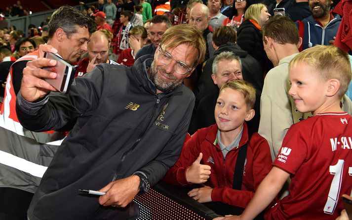 Jürgen Klopp afslappaður með ungum stuðningsmanni Liverpool.