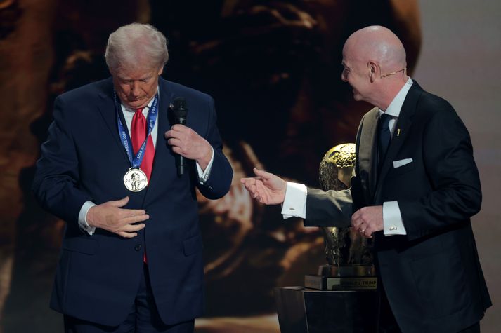 Donald Trump er fyrsti handhafi nýju Friðarverðlauna FIFA. Hann var fljótur að setja verðlaunapeninginn um hálsinn.