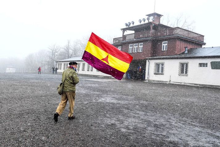 Maður heldur á fána alþjóðaherdeildarinnar úr spænska borgarastríðinu við minningarathöfn um frelsun útrýmingabúðanna í Buchenwald árið 2019.