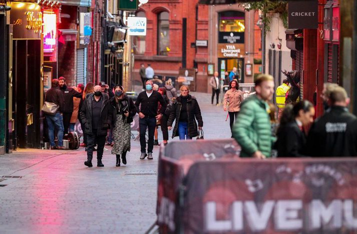 Íbúar í Liverpool sjást hér á ferð í miðbænum með grímur en búist við verulega hertum aðgerðum í borginni vegna útbreiðslu kórónuveirunnar.