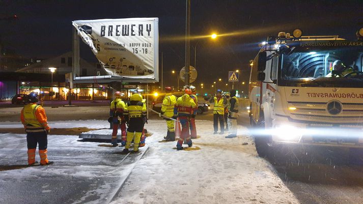 Björgunarsveitarmenn reyna að bjarga skilti við Bryggjuna brugghús úti á Granda.