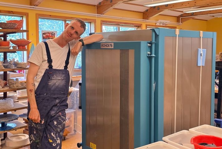 Kristján Atli Sævarsson göngugarpur og íbúi á Sólheimum við nýja brennsluofninn, sem hann safnaði fyrir.