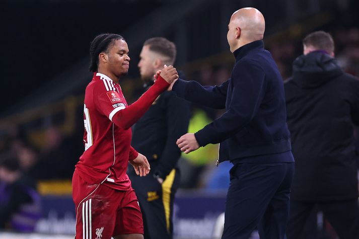 Arne Slot tekur á móti Rio Ngumoha eftir að hann tók hann af velli í bikarsigri Liverpool.