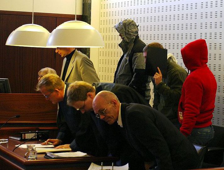 Í Héraðsdómi. Sakborningar í Dettifossmálinu hylja andlitin. Máli Tryggva Lárussonar var vísað aftur í héraðsdóm.