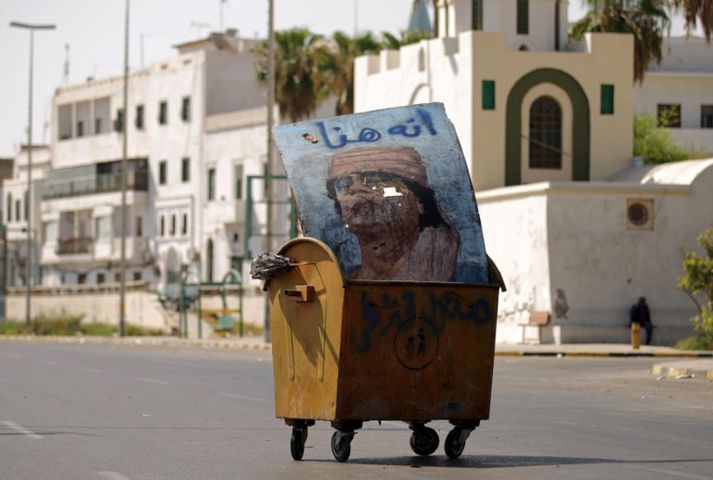 Hér hefur einhver látið mynd af Gaddafi vaða í ruslagám.