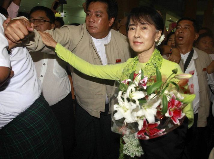 Aung San Suu Kyi tók við blómvendi þegar hún lagði af stað til Bandaríkjanna.