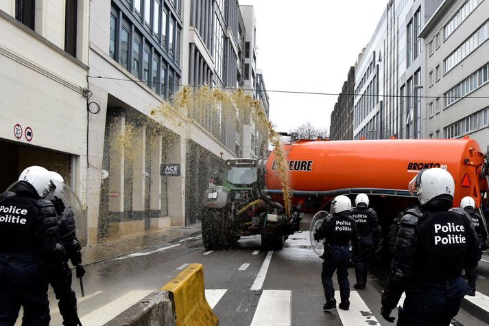 Bændur sprautuðu mykju yfir lögreglumenn í Brussel. 