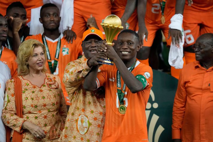 Alassane Ouattara forseti með Max-Alain Gradel  sem lyftir bikarnum eftir sigur Fílabeinsstrandarinnar í Afríkukeppninni.