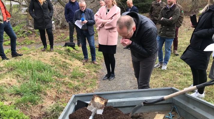 Guðmundur Ingi Guðbrandsson, umhverfisráðherra, þefar af eyfirskri moltu, unna úr ýmsum lífrænum úrgangi.