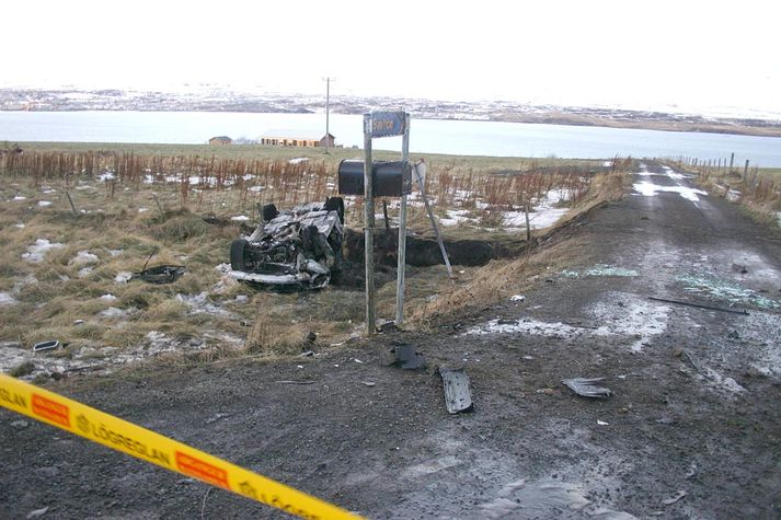 Brunnið flak bílsins á slysstað.