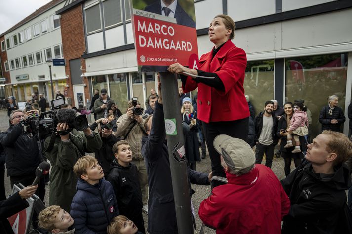 Mette hengir upp kosningaplakat fyrir borgarstjórann í Herlev. Stefnubreyting hennar gæti kostað Jafnaðarmenn völdin í höfuðborginni.