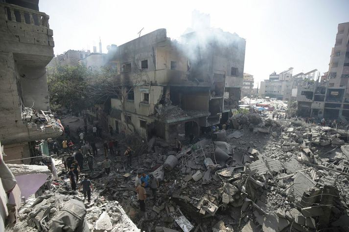 Palestínumenn kanna húsarústir eftir sprengjuárás Ísraela í Nuseirat-flóttamannabúðunum á laugardag. Fjórir gíslar voru frelsaðir í árásinni en Hamas segja að á þriðja hundruð manns hafi fallið.