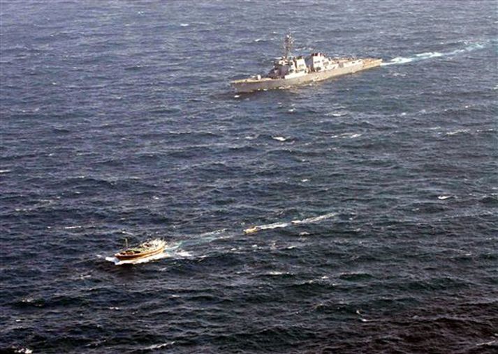 Bandaríska herskipið USS Winston S. Churchill, fjær, eltir meint sjóræningjaskip á Indlandshafi á laugardag.